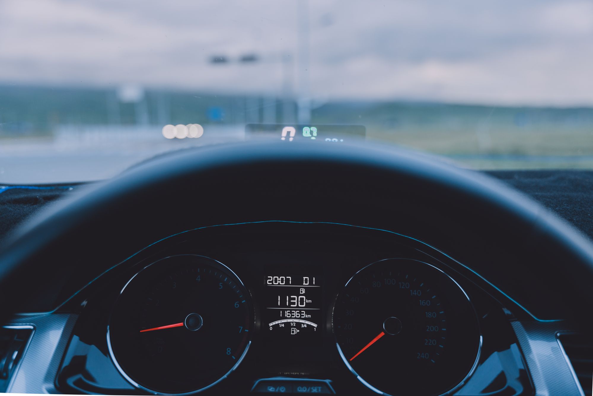 View over a car dashboard and steering wheel toward the road