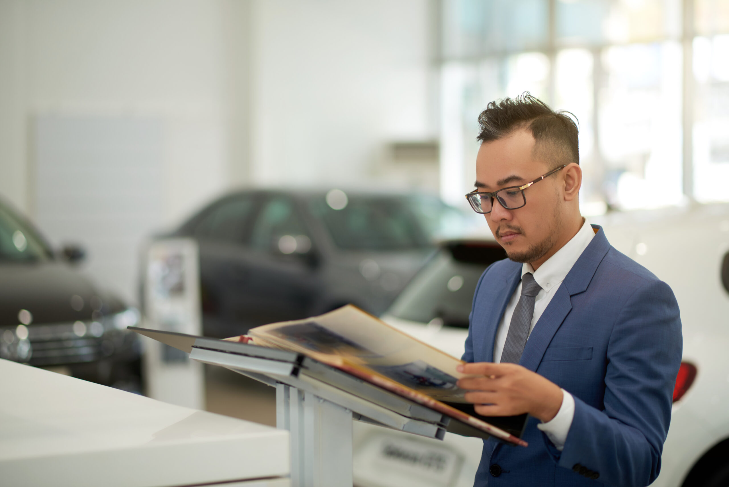 F&I manager reviewing digital reports to track contracts-per-sale and improve product penetration in an auto dealership setting