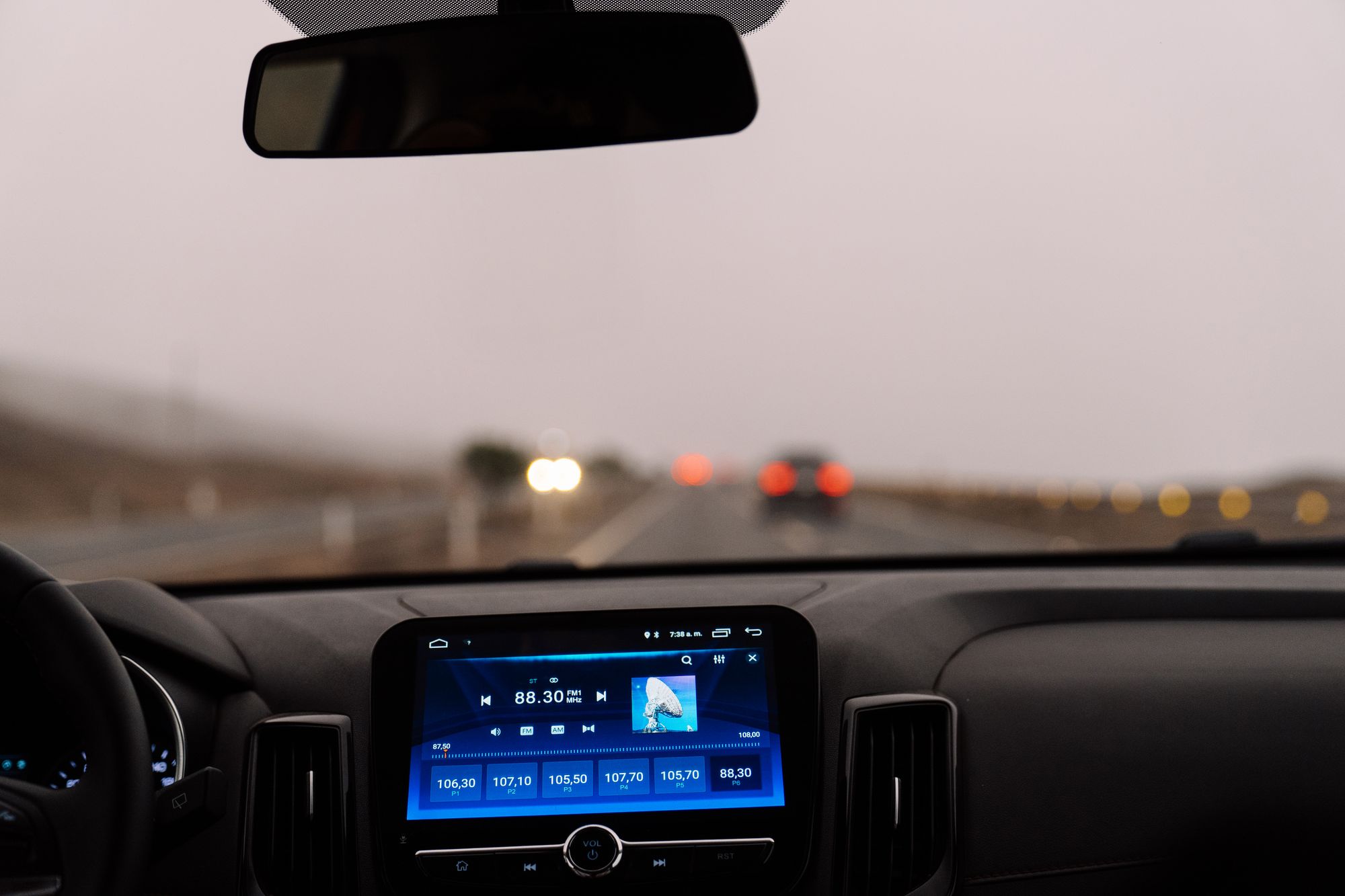 Car dashboard view from the driver seat looking at the road