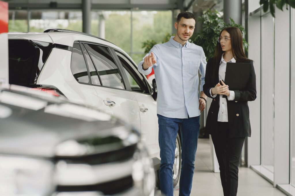 Dealership employee working with a client on a vehicle sale