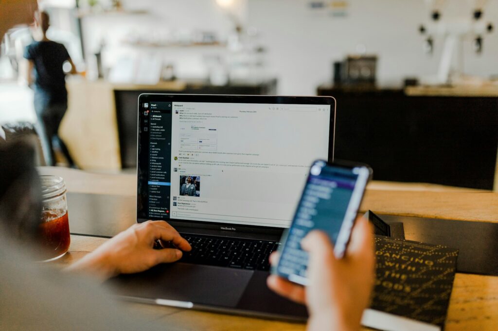 Person using a phone and laptop to research before a call